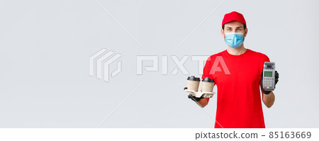 Takeaway, food and groceries delivery, covid-19 contactless orders concept. Friendly employee in red uniform, courier face mask and gloves, giving client POS terminal with coffee Takeaway, food and groceries delivery, covid-19 contactless orders concept. Friendly employee in red uniform, courier face mask and gloves, giving client POS terminal with coffee 85163669