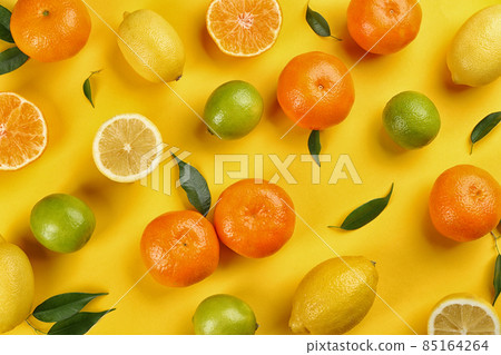 Flat lay composition with tangerines and different citrus fruits on yellow background 85164264