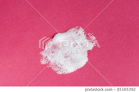 White foam texture from soap, detergent, shampoo, shaving foam or cleanser on a pink background. Cleansing product texture 85165392
