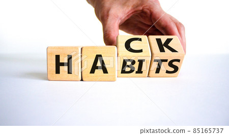 Hack habits symbol. Doctor turns wooden cubes with words 'Hack habits'. Beautiful white table, white background. Psychology, hack habits concept. Copy space. Hack habits symbol. Doctor turns wooden cubes with words 'Hack habits'. Beautiful white table, white background. Psychology, hack habits concept. Copy space. 85165737