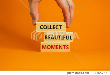 Collect beautiful moments symbol. Wooden blocks with words 'Collect beautiful moments'. Beautiful orange background, businessman hand. Business, collect beautiful moments concept, copy space. 85165754