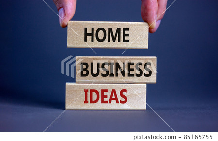 Home business ideas symbol. Wooden blocks form the words 'Home business ideas' on beautiful grey background. Businessman hand. Business, home business ideas concept. Copy space. 85165755