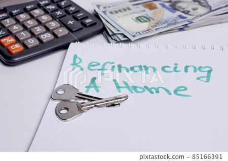 Refinancing a home concept. House keys, calculator and money Refinancing a home concept. House keys, calculator and money 85166391