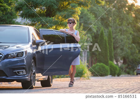Young woman standing beside her car waiting for someone. Travelling and vacations concept. 85166531