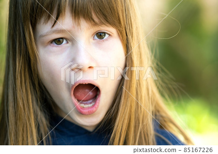 Portrait of surprised child girl outdoors in summer. Shocked female kid on a warm day outside. 85167226