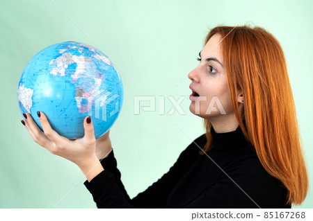 Portrait of a sad worried young woman holding geographic globe of the world in her hands. Travel destination and planet protection concept. Portrait of a sad worried young woman holding geographic globe of the world in her hands. Travel destination and planet protection concept. 85167268