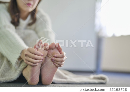 Cold young woman massaging her feet 85168728