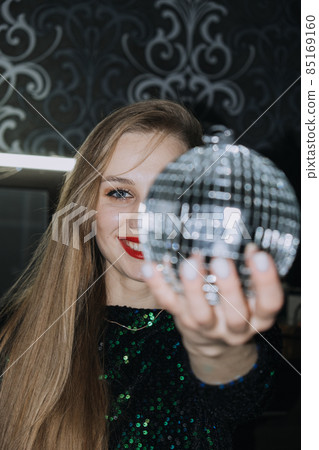 Nightlife, New year eve party, New year celebration. Portrait of young beautiful woman and disco ball 85169160