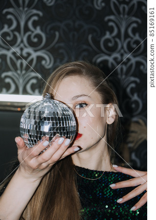 Nightlife, New year eve party, New year celebration. Portrait of young beautiful woman and disco ball 85169161