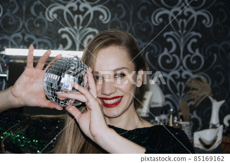 Nightlife, New year eve party, New year celebration. Portrait of young beautiful woman and disco ball 85169162