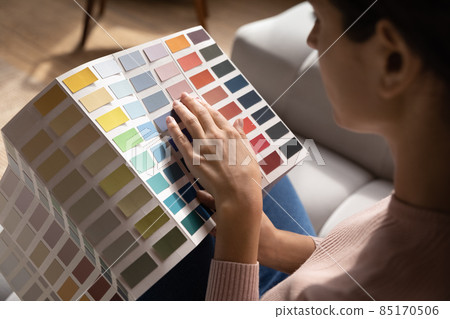 Close up woman choosing color from samples catalogue, renovation concept 85170506