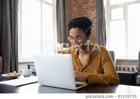Happy young African American woman working on computer at home. 85170733