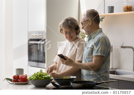 Happy mature married couple cooking in home kitchen 85170857