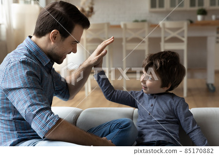 Overjoyed father and little son giving high five, celebrating success Overjoyed father and little son giving high five, celebrating success 85170882