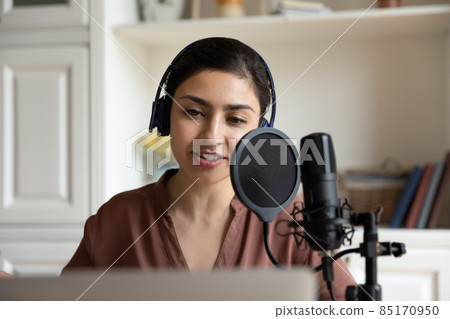 Beautiful young indian woman recording song or voice acting. Beautiful young indian woman recording song or voice acting. 85170950