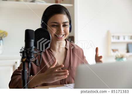 Smiling young indian woman recording voice at home. 85171383