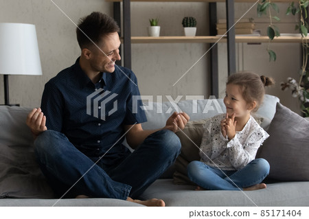 Happy dad teaching cheerful preschool daughter to meditate at home 85171404