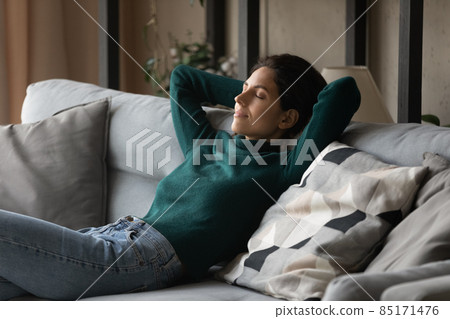 Calm Hispanic woman relax on sofa sleeping Calm Hispanic woman relax on sofa sleeping 85171476