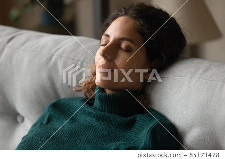 Calm millennial latina woman taking break for relax on couch 85171478