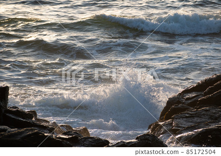 Waves shining reflecting the sunset Waves shining reflecting the sunset 85172504