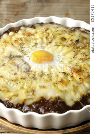 Freshly baked curry with plenty of melting cheese and eggs Freshly baked curry with plenty of melting cheese and eggs 85173415