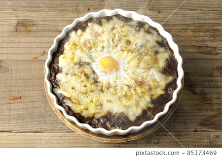 A bird's-eye view of a freshly baked curry with plenty of melted cheese and eggs A bird's-eye view of a freshly baked curry with plenty of melted cheese and eggs 85173469