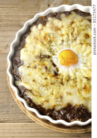 A bird's-eye view of a freshly baked curry with plenty of melted cheese and eggs A bird's-eye view of a freshly baked curry with plenty of melted cheese and eggs 85173477