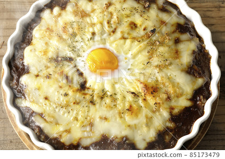 A bird's-eye view of a freshly baked curry with plenty of melted cheese and eggs A bird's-eye view of a freshly baked curry with plenty of melted cheese and eggs 85173479