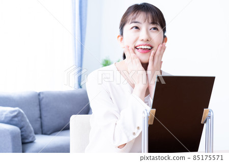 一個女人出門前在鏡子裡檢查她的妝容 85175571