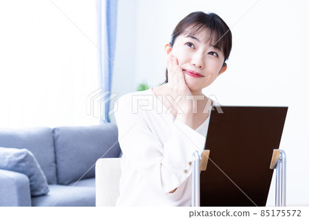 一個女人出門前在鏡子裡檢查她的妝容 85175572
