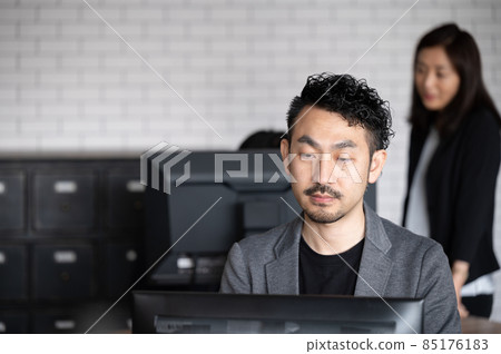 There is a copy space for an engineer-like man who works on a computer and looks down. 85176183