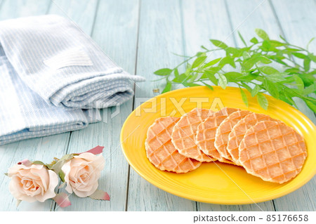 Butter waffles, light blue cloth and roses on a yellow plate 85176658