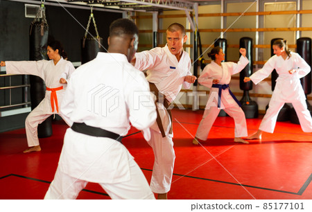 Men fighting during group karate training in gym 85177101