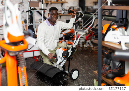 Customer takes close look at new street sweeper at tool store 85177117