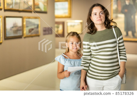 Woman with daughter looking at painting in the museum 85178326