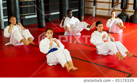 Athletes man and woman in kimono doing abdominal exercise 85178329
