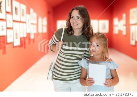 Woman with girl looking at modern painting in museum of art Woman with girl looking at modern painting in museum of art 85178373