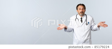 Covid-19, coronavirus outbreak, healthcare workers and pandemic concept. Clueless and indecisive bearded male doctor in white coat, shrugging and looking troubled answer, dont know Covid-19, coronavirus outbreak, healthcare workers and pandemic concept. Clueless and indecisive bearded male doctor in white coat, shrugging and looking troubled answer, dont know 85179224