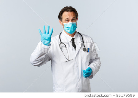 Covid-19, preventing virus, healthcare workers and vaccination concept. Professional doctor at clinic explain four steps to protect health from infection, wearing medical mask and gloves 85179599