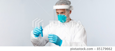 Covid-19, preventing virus, healthcare workers and vaccination concept. Serious-looking doctor in personal protective equipment carefully examine test tube with vaccine sample Covid-19, preventing virus, healthcare workers and vaccination concept. Serious-looking doctor in personal protective equipment carefully examine test tube with vaccine sample 85179662