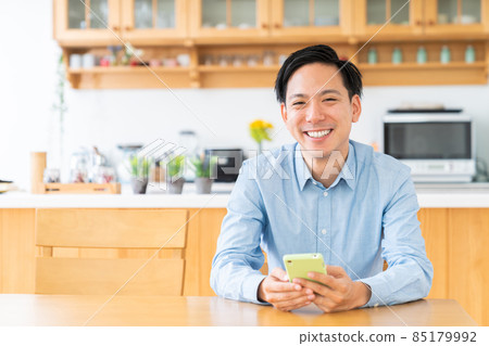 一個男人看著房間裡的智能手機 一個男人看著房間裡的智能手機 85179992