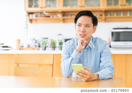 考慮一個男人在房間裡看智能手機 考慮一個男人在房間裡看智能手機 85179993