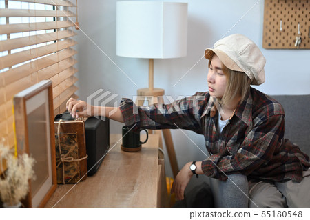 Young woman adjusting and control the volume on the speaker. 85180548