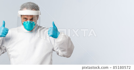 Covid-19, preventing virus, healthcare workers and vaccination concept. Confident doctor working with coronavirus patients in personal protective equipment, show thumb-up, assure everything alright 85180572