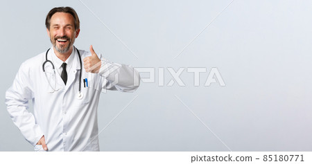 Covid-19, coronavirus outbreak, healthcare workers and pandemic concept. Optimistic happy doctor advice medication or clinic service, ensure quality, showing thumbs-up in approval Covid-19, coronavirus outbreak, healthcare workers and pandemic concept. Optimistic happy doctor advice medication or clinic service, ensure quality, showing thumbs-up in approval 85180771