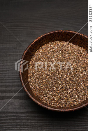 Organic natural chia seeds in wooden bowl close-up on dark wooden background or table 85183584