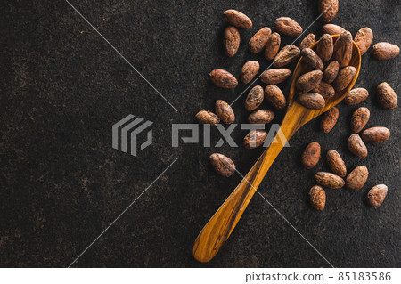 Dried cocoa beans. Cacao beans on wooden spoon. 85183586