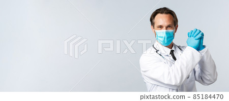 Covid-19, preventing virus, healthcare workers and vaccination concept. Encouraged and determined optimistic doctor in medical mask and gloves, clench hands together in victory 85184470