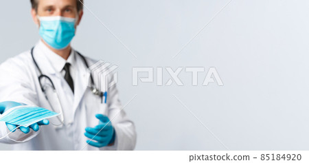 Covid-19, virus, healthcare workers and vaccination concept. Doctor in PPE handing you medical mask, explain preventive measures not catching coronavirus disease, worry patient health Covid-19, virus, healthcare workers and vaccination concept. Doctor in PPE handing you medical mask, explain preventive measures not catching coronavirus disease, worry patient health 85184920
