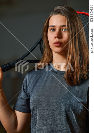 Female tennis player with racket and ball on gym background 85185433